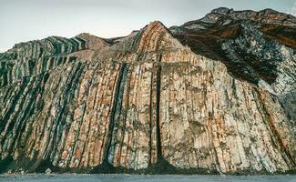 Colored layers of stones in section of the mount, different rock formations and soil layers. photo