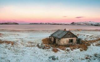 Panoramic view of abandoned house against the Arctic sky. Old authentic village of Teriberka. Kola Peninsula. photo