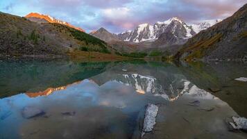 Picturesque mountain lake in the dramatic day, Altai. Beautiful reflection of mountains, sky and white clouds. Panoramic view. photo