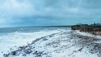 Dramatic stormy day on the beach. Kashkarantsy fishing collective farm. A small authentic village on the White sea coast. Kola Peninsula. Russia photo