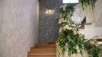 Spiral- Treppe im das Innere mit Blumen. Dekor mit Blumen auf das Stufen. Hochzeit Dekorationen video