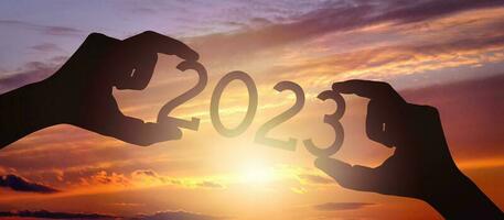 2023 - Human Hands Holding Black Silhouette Year Number photo