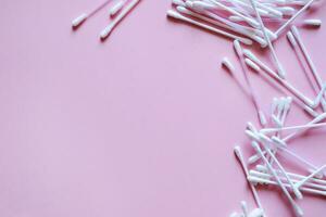 cotton swabs on a pink background on the right, cosmetic and medical accessories, a beauty salon banner, with a place for text photo