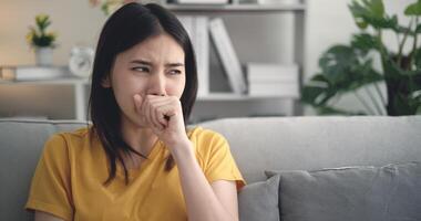 Young Asian woman suffering from flu, coughing and sneezing at home photo