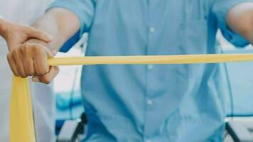 Doctor or Physiotherapist working examining treating injured arm of athlete male patient, stretching and exercise, Doing the Rehabilitation therapy pain in clinic. video