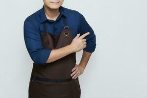 Asian Man wearing Apron in casual stylish clothing, standing upright pose with one hand pointing at something on the right, no face isolated white background photo