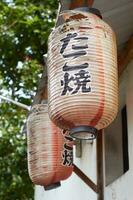 old and torn Traditional Japanese shop sign lantern, hung in front of the store photo