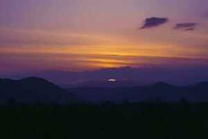 Dom ocultación detrás el montañas. puesta de sol antecedentes. foto