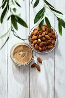 Jar of almond butter with almonds heap. Homemade almond butter, natural, healthy food. photo