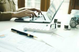 Woman accountant working on laptop computer while counting taxes online. photo