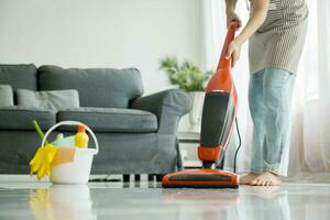 Young woman cleaning house with vacuum cleaner. photo