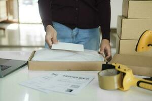 Female online business owner packing package. photo