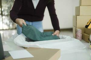 Businesswoman folding clothes for online order. photo