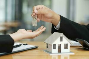 Real estate agent giving house keys to client after signing contract. photo