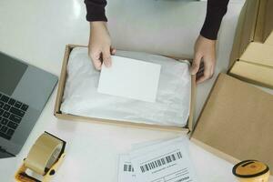 Female online business owner packing package. photo