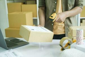 Young entrepreneur scanning online order box. photo