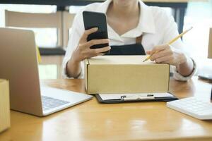 Female online business owner checking order using cellphone. photo