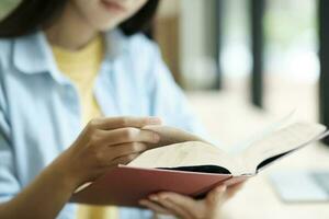 cerca arriba de mujer estudiando y leyendo libro. foto