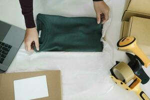 Businesswoman folding clothes for online order. photo