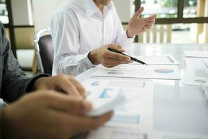 Asisan businessman teamwork meeting and discussing the investment data and report graph. photo