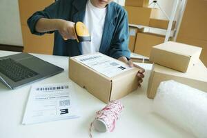 Young entrepreneur scanning online order box. photo