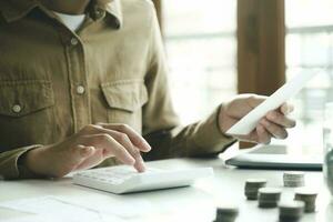 Accountant using calculator for calculate finance report in office photo