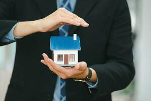 Businessman holding a house model. photo