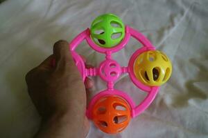 a colorful toddler toy that can make a tinkling sound with a pink handle photo