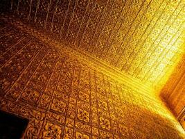 Burmese art pattern motifs decorative design on the golden walls of the rooms in the temple photo