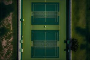 couple of tennis courts sitting on top of a lush green field. . photo