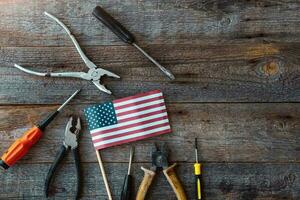 Happy Labor day. Construction tools and the USA America flag . Copy space for text on wood background. photo