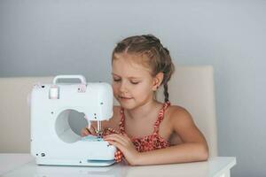 7 7 años antiguo niño estudiando trabajo con un moderno de coser máquina. pasatiempo. foto