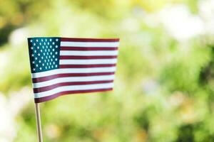 americano bandera en un borroso verde antecedentes. labor día fiesta concepto. 4to de julio Estados Unidos independencia día. Copiar espacio para texto. foto