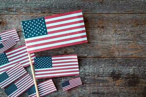 Many American flags and sequins on a wooden background, flat lay. A holiday in America. 4th of july, happy independence day of the united states. Happy labour day. Copy space for text. photo