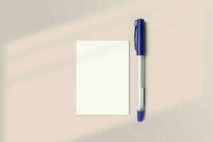 Realistic A7 paper flatlay mockup with a pen. Portrait A7 International Paper Size mockup top view. Simple, clean, modern, minimal small paper mock up flat lay concept photo