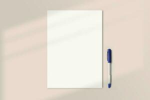 Realistic A4 paper flatlay mockup with a pen. Portrait paper A4 International Paper Size mockup top view. Simple, clean, modern, minimal paper sheet mock up flat lay concept photo