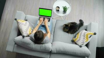 Overhead shot of woman using laptop with green mock-up screen video