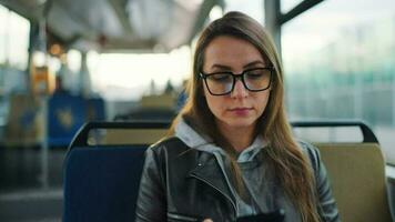 Öffentlichkeit Transport. Frau im Brille im Straßenbahn mit Smartphone, schleppend Bewegung video