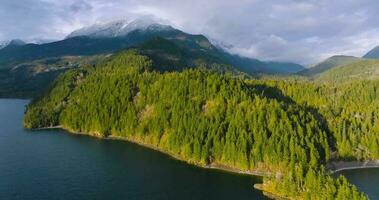 Aerial view of Harrison Lake and forest with mountain range in background video