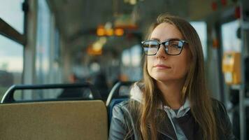 Öffentlichkeit Transport. Frau im Brille Reiten ein Straßenbahn im das Stadt, schleppend Bewegung video
