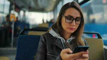 público transporte. mulher dentro óculos dentro eléctrico usando Smartphone, lento movimento video