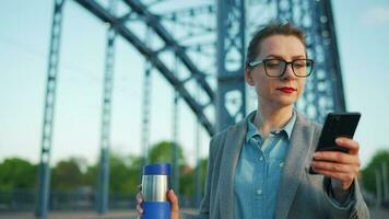 Woman in a coat, walking around the city in the early morning, drinking coffee video