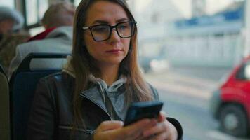 Öffentlichkeit Transport. Frau im Brille im Straßenbahn mit Smartphone video