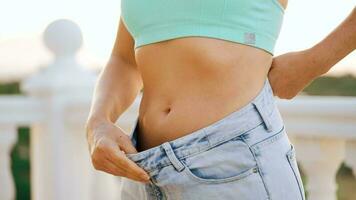 Frau genießen Gewicht Verlust beim heim. weiblich im alt Jeans nach erfolgreich Diät. video