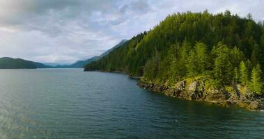 Aerial view of Harrison Lake and forest with mountain range in background video