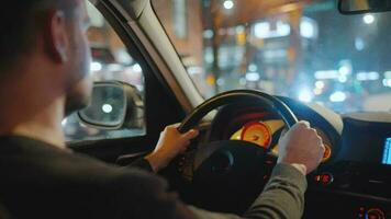 homme conduite voiture par le des rues de nuit ville. video