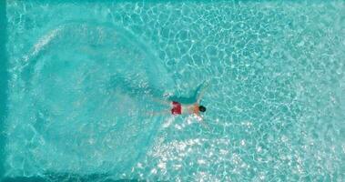 aéreo ver como un hombre inmersiones dentro el piscina y nada video