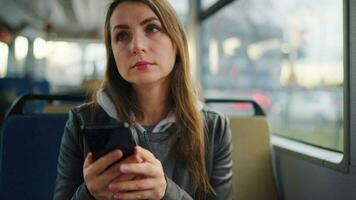 Public transport. Woman in tram using smartphone, slow motion video