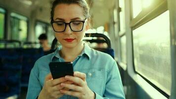 público transporte. mulher dentro óculos dentro eléctrico usando Smartphone. lento movimento video