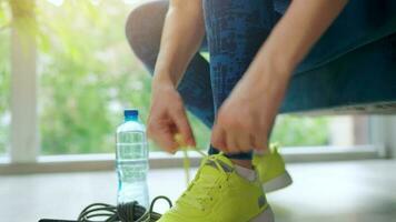 Woman tying shoelaces on sneakers going for training or jogging video